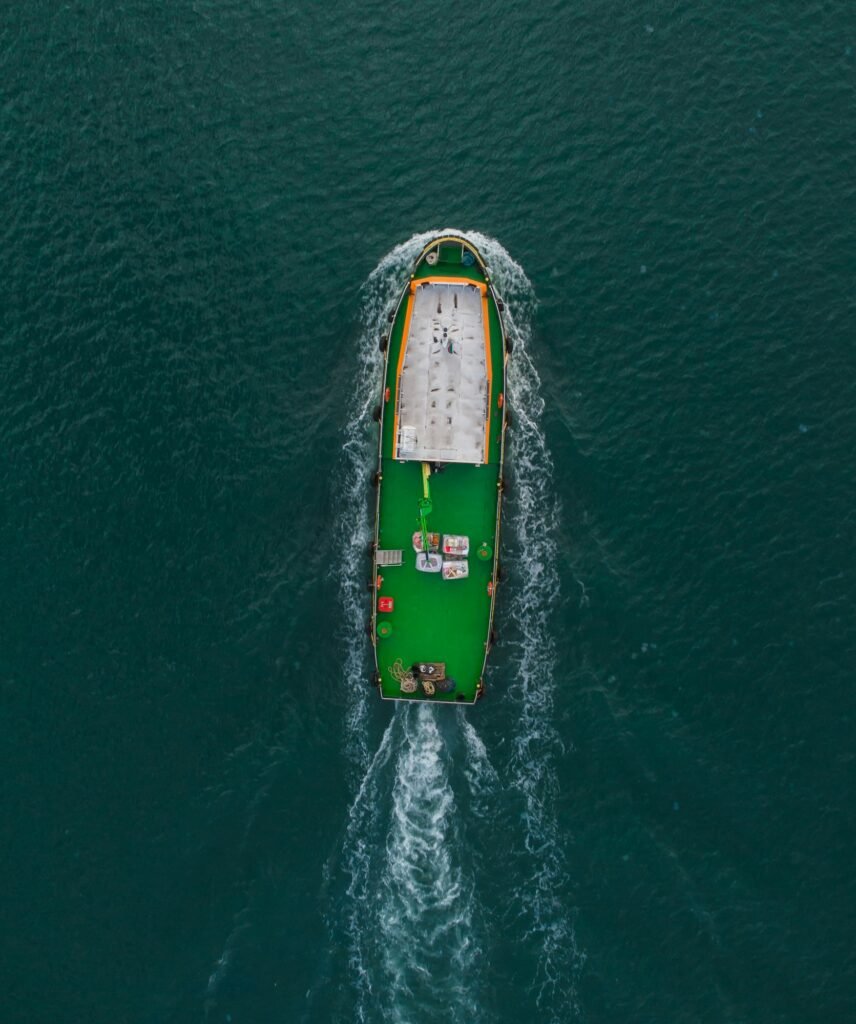 Aerial drone view of industrial tug assisting boat in deep sea